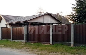 коричневый забор из профнастила с бетонными столбами в деревне